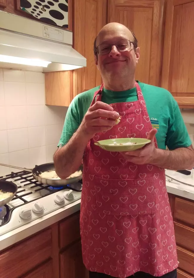 Terry testing latkes to make sure they're OK